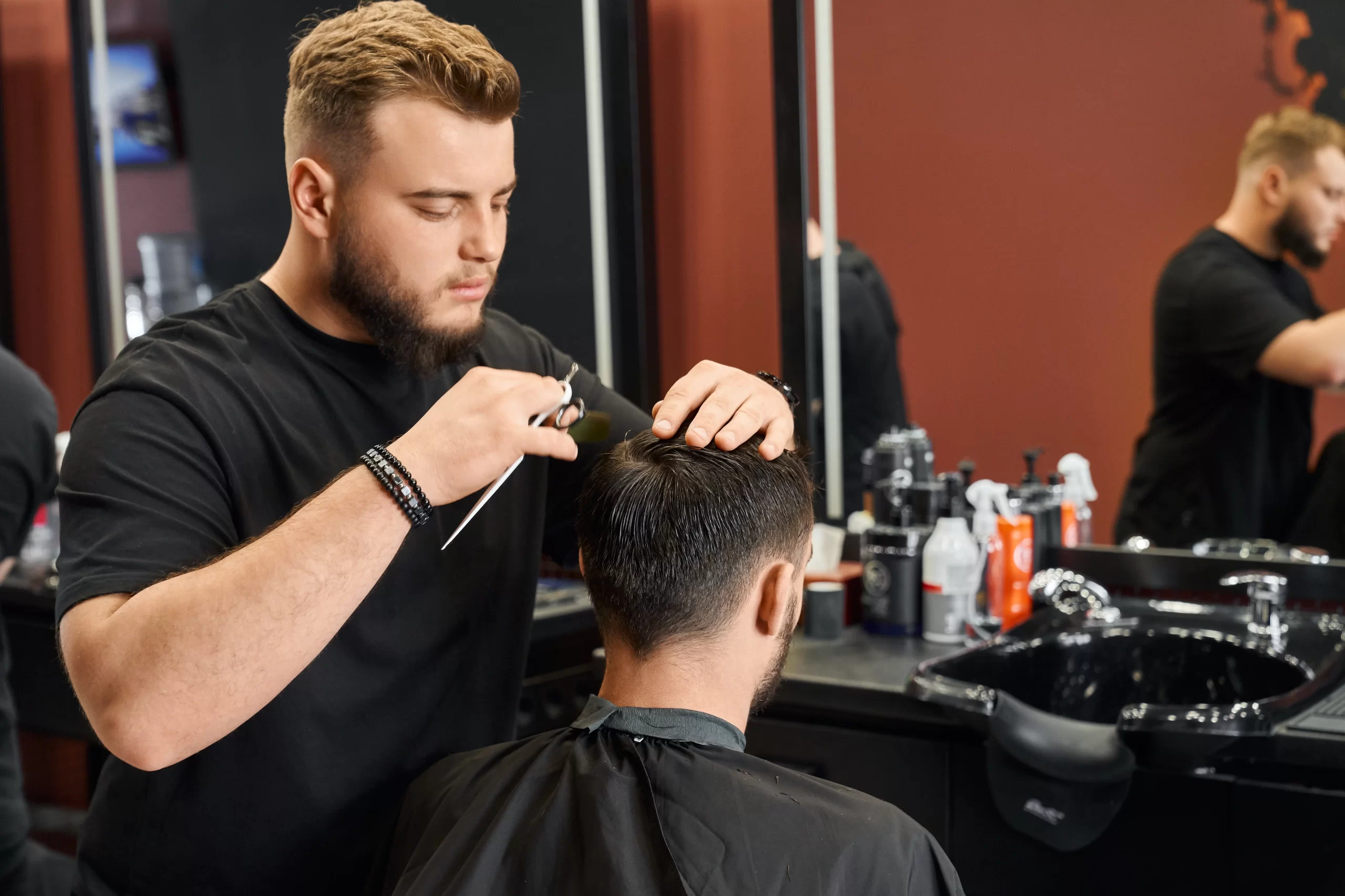 competent-barber-cutting-client39s-hair-with-sharp-scissors